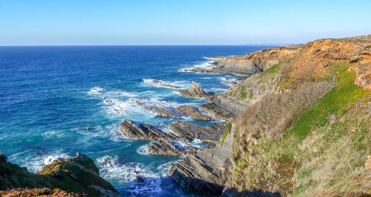 Rotsachtige klifkustlijn met levendige blauwe Atlantische golven en een heldere horizon