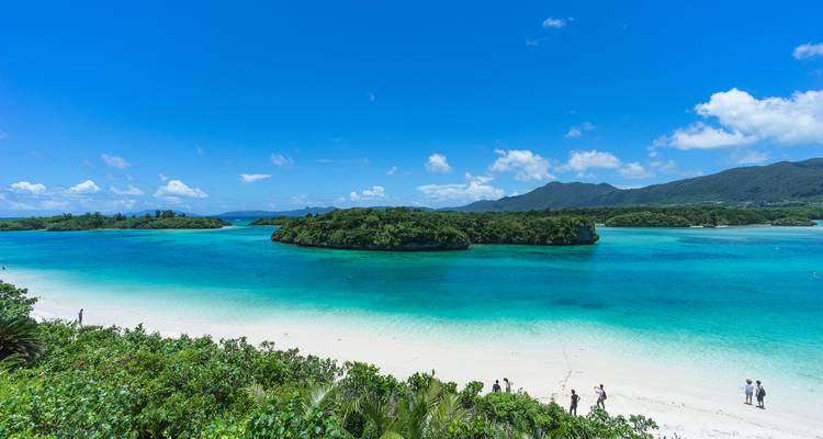 Vue panoramique de mer émeraude et de petites îles couvertes de jungle sous un ciel bleu éclatant