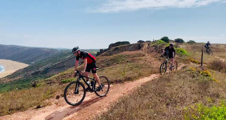 Radfahrer fahren auf Singletrack entlang der Küstenklippen mit Meerblick darunter