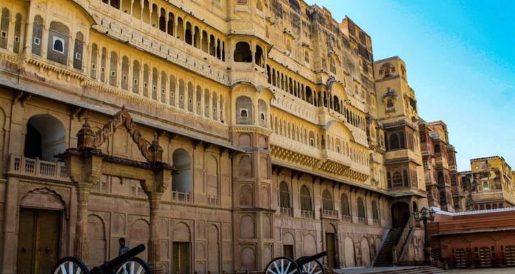 Binnenplaats van het massieve zandstenen Junagarh Fort met kanonnen die de gewelfde gevel bewaken.