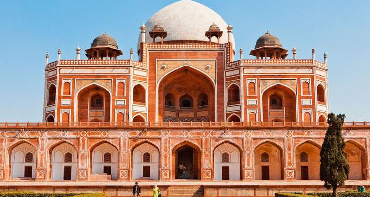 Majestuosa Tumba de Humayun de arenisca roja con techo de doble cúpula contra un cielo azul claro.