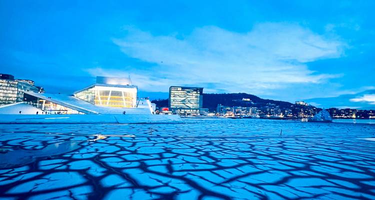 Modernes Osloer Opernhaus und Skyline spiegeln sich in aufgerissenem blauen Eis unter einem Dämmerhimmel
