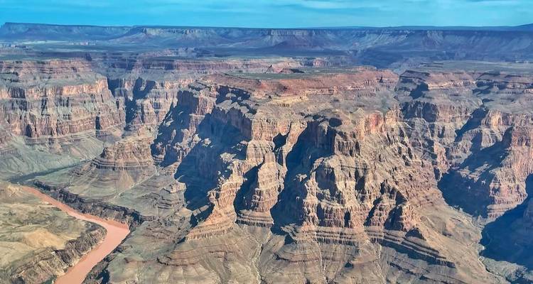 Indrukwekkend luchtfoto van de gelaagde rotswanden van de Grand Canyon met de Colorado River eronder.