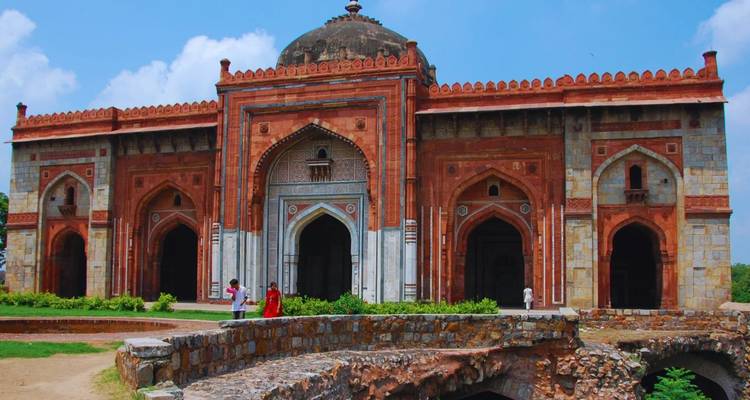Besucher gehen an den gewölbten Tordurchgängen des Hauz Khas Madrasa-Komplexes aus dem 14. Jahrhundert in Delhi vorbei.