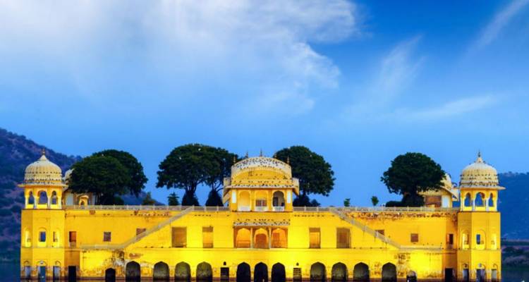 Jaipurs beleuchteter Jal Mahal-Palast scheint bei Dämmerung auf den ruhigen Gewässern des Man Sagar-Sees zu schweben.