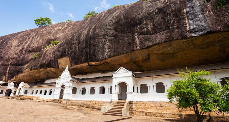 Lange Fassade des Dambulla-Höhlentempels, geschützt unter einer enormen überhängenden Felswand.