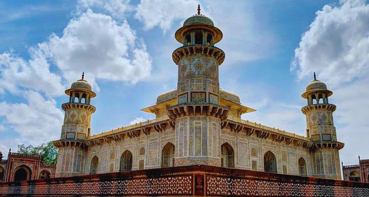 La tumba de Itimad-ud-Daulah intrincadamente decorada, conocida como el "Taj Bebé", bajo un cielo parcialmente nublado.
