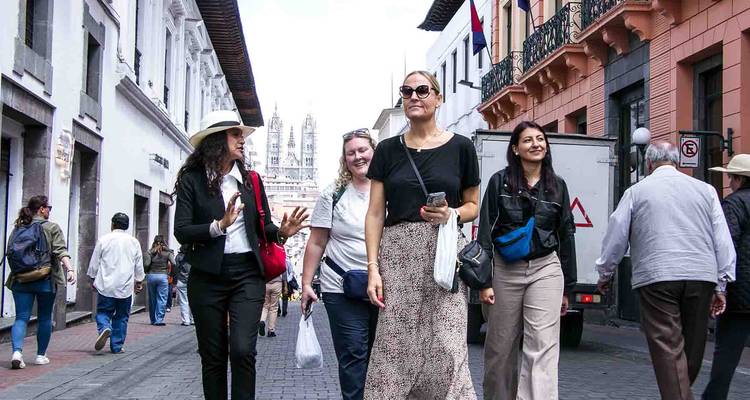 Walking tour through historic Quito street with guide speaking to small group of visitors.