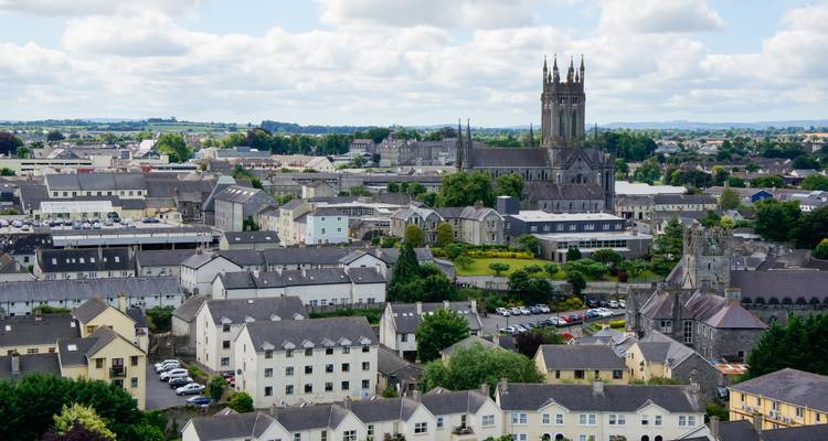 Vue panoramique sur Kilkenny avec sa haute cathédrale et ses maisons aux toits gris sous des nuages épars