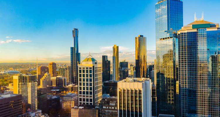 Luz de hora dorada iluminando las torres de cristal y el paisaje urbano de Melbourne desde un punto elevado