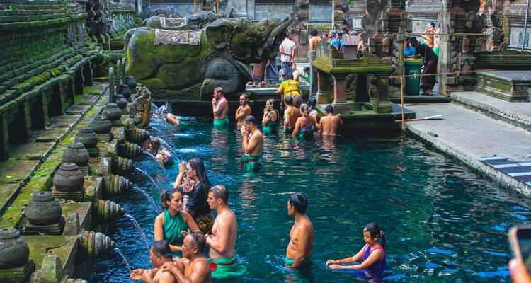 Locals and tourists bathe in the holy spring pools of Tirta Empul Temple.