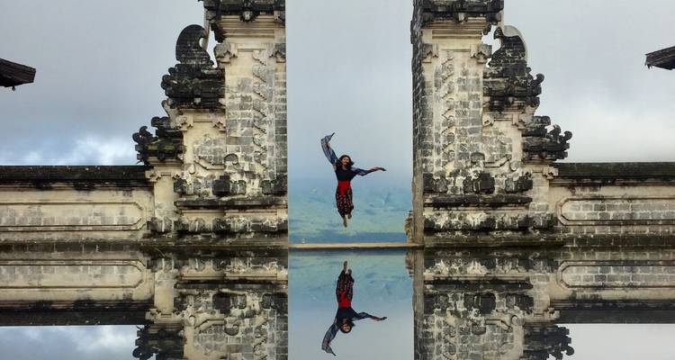 Traveler leaps joyfully between the ‘Gates of Heaven’ temple pillars with mirror-like reflection.