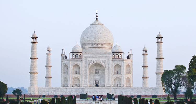 Vista frontal del reluciente Taj Mahal de mármol blanco enmarcado por minaretes y jardines tranquilos.