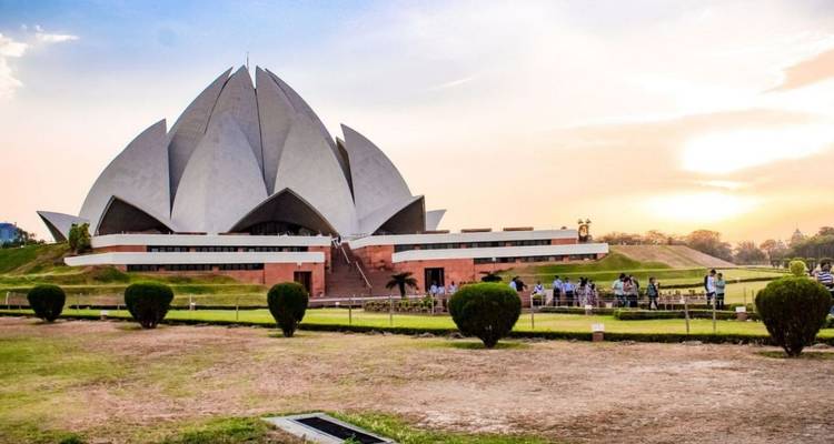 Futurista Templo del Loto de pétalos blancos situado en jardines cuidados bajo un cielo de atardecer pastel.