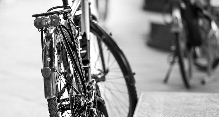 Gros plan en noir et blanc de la roue arrière et de la chaîne d'un vélo vintage.
