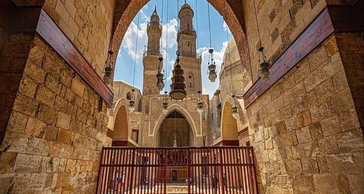 Interior view through an arched entrance to Al-Azhar Mosque’s courtyard and twin minarets.