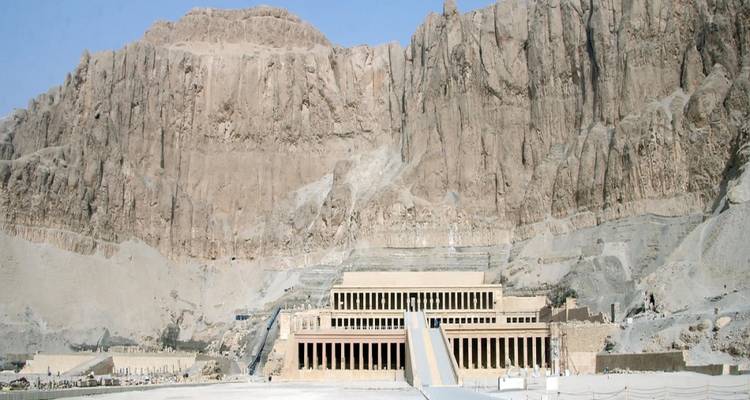 The terraced Temple of Hatshepsut set against dramatic desert cliffs under a clear blue sky.