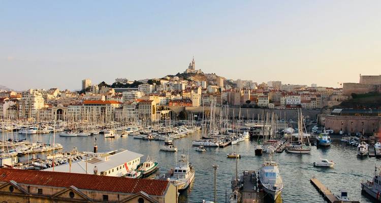 Vue panoramique du soir du Vieux-Port de Marseille rempli de mâts sous Notre-Dame de la Garde