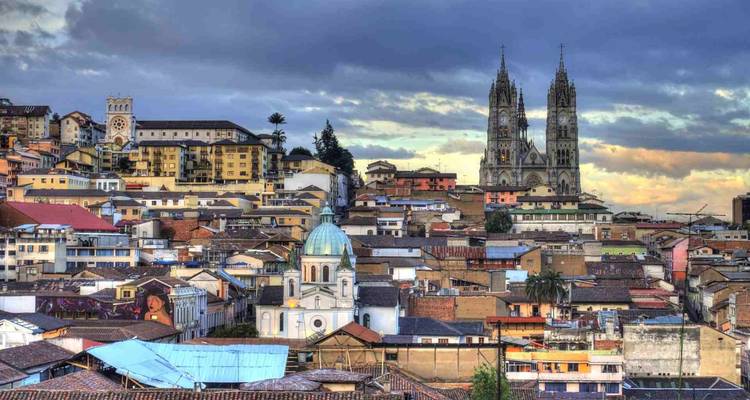 Panoramic view of Quito’s old town rooftops with cathedral spires rising against a moody sky.