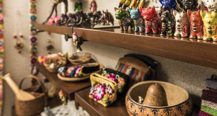 Regale mit bunten peruanischen Kunsthandwerk, Töpferwaren und bestickten Taschen in einem Geschenkeladen.