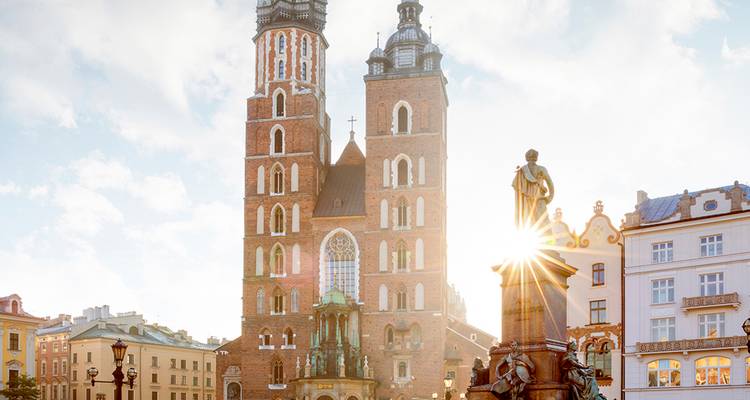 La luz del sol irrumpe detrás de las torres gemelas de la Basílica de Santa María en la plaza histórica de Cracovia