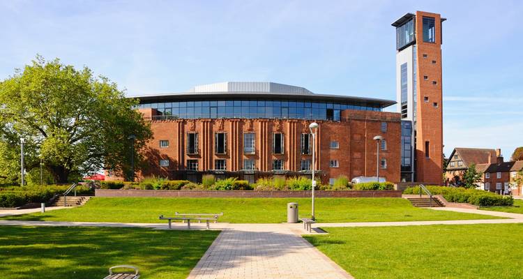 Théâtre Royal Shakespeare moderne en briques rouges avec une haute tour situé au milieu de pelouses et d'allées soigneusement entretenues.