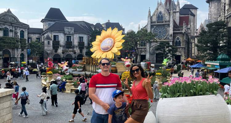 Besucher posieren inmitten farbenfroher Blumenarrangements und Fassaden im europäischen Stil im Themenpark Ba Na Hills