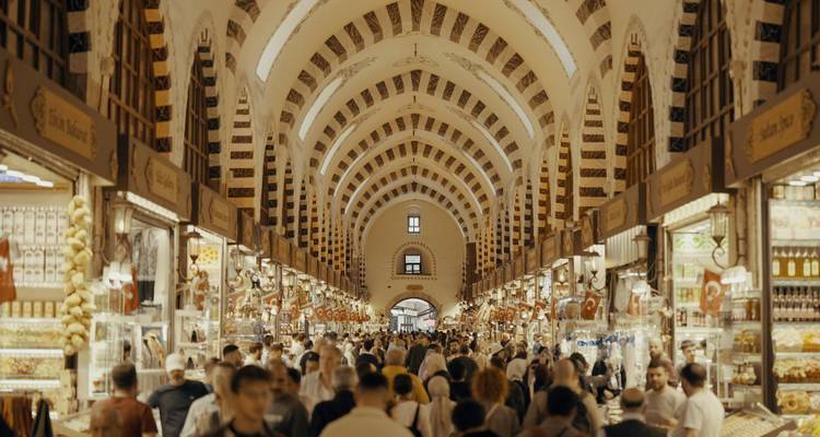 Interior abarrotado del Bazar de las Especias de Estambul con techo abovedado y puestos de mercancías a ambos lados.