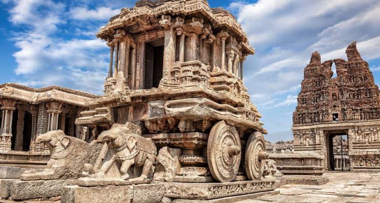 Iconische stenen strijdwagen van het Vittala tempelcomplex onder een heldere blauwe hemel in Hampi.