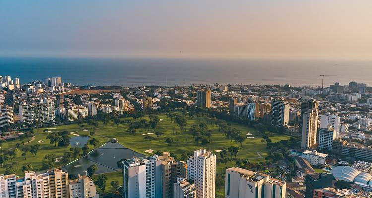 Aerial twilight view over Lima’s Miraflores district golf course and Pacific coastline.