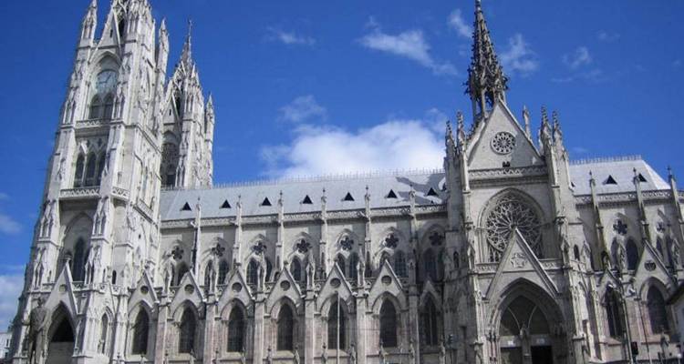 Gothic façade of the Basilica del Voto Nacional rising against a vivid blue sky in Quito.