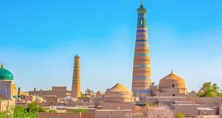 Le minaret coloré de Kalta Minor et la ligne d'horizon de Khiva sous un ciel bleu dégagé