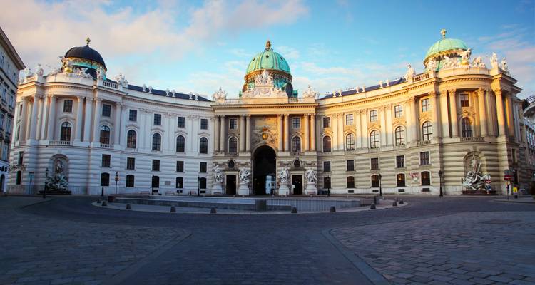 Vroeg ochtendlicht op de grootse gebogen gevel en koepels van het Michaelertrakt van het Hofburg Paleis in Wenen.