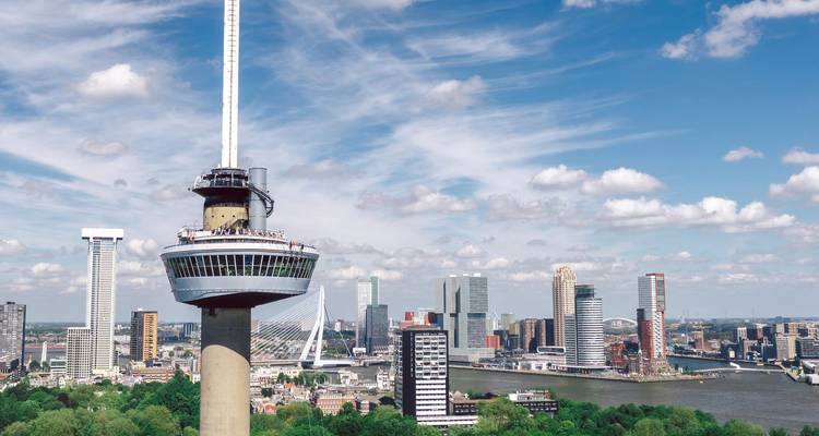 Horizon de Rotterdam avec la tour Euromast et des ponts modernes sous un ciel lumineux.