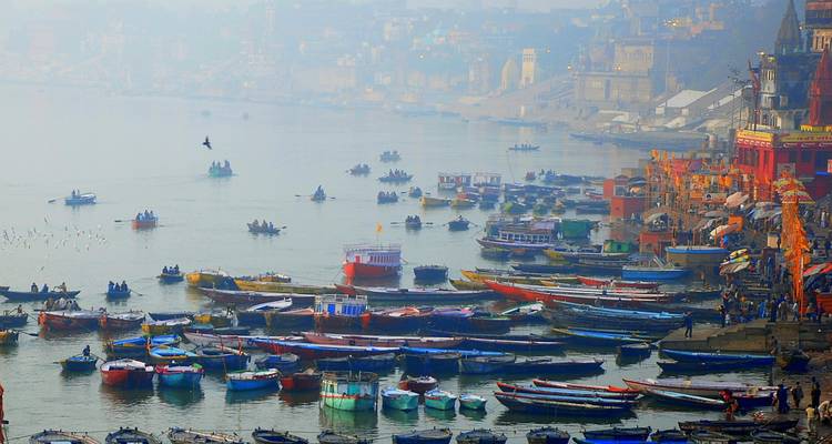 Hazy panoramic view of boats and ghats along the Ganges River.