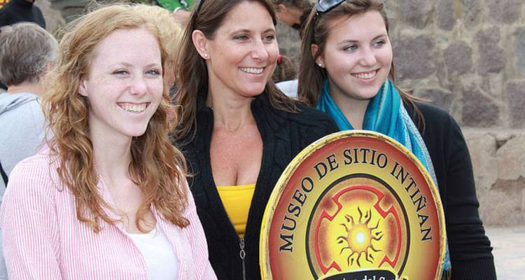 Drei Touristen lächeln mit einem Museo de Sitio Intiñan-Schild im Äquatormuseum.