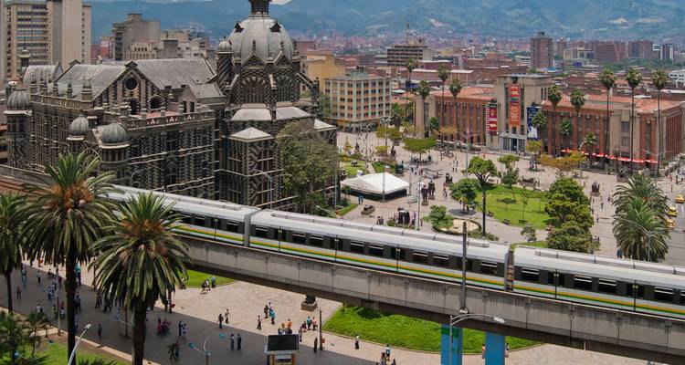 Downtown Medellín with ornate Palacio de la Cultura, metro train and Plaza Botero below.