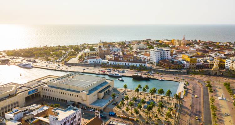 Drone shot of Cartagena’s walled old town, harbor basin and Caribbean shoreline in soft afternoon light.