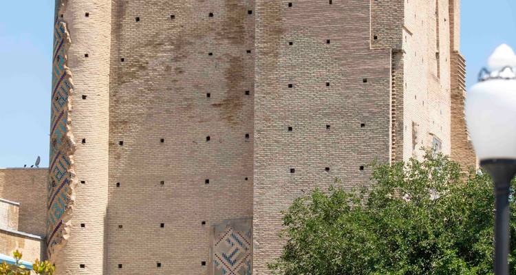 Gros plan d'un mur de tour haute en brique avec des bandes décoratives en carrelage.