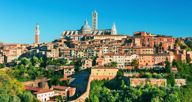 Klassieke skyline van Siena met kathedraal en Torre del Mangia onder blauwe hemel