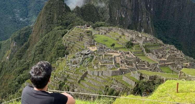 Un voyageur contemple les ruines emblématiques du Machu Picchu depuis un point de vue panoramique.
