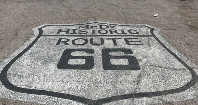 Écusson historique de la Route 66 peint sur une chaussée d'asphalte fissurée vue d'en haut.