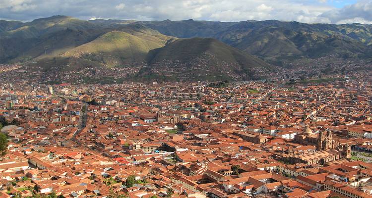 Vue aérienne des toits de terre cuite de Cusco s'étendant dans une vallée entourée par les montagnes des Andes