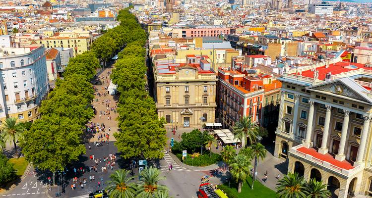 Aérea de La Rambla de Barcelona bordeada de árboles que se extiende hacia bloques urbanos concurridos y edificios históricos