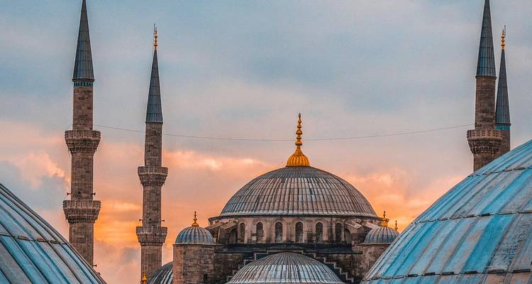 Silueta de las cúpulas y minaretes de la Mezquita Azul recortada contra un cielo vespertino en tonos pastel