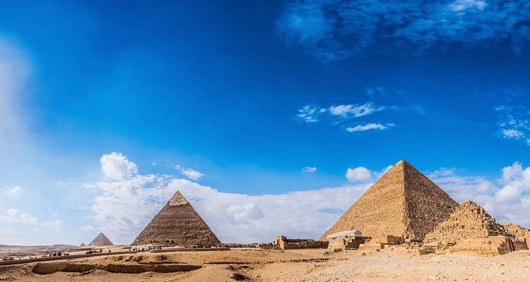 Amplia vista panorámica de las pirámides de Giza bajo un cielo azul vibrante