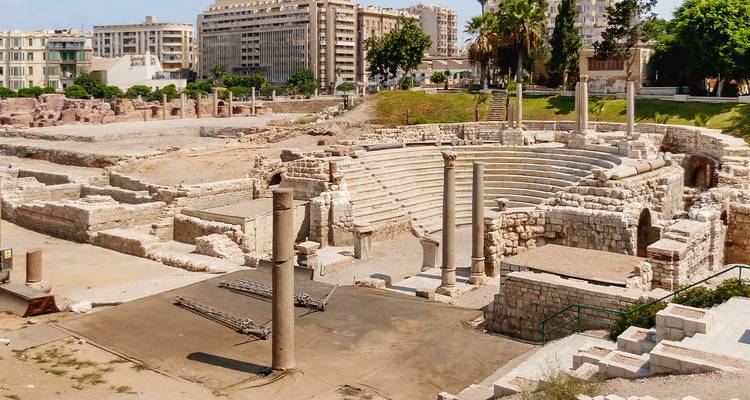 Ruinas de teatro romano antiguo en Alejandría con edificios modernos de la ciudad detrás