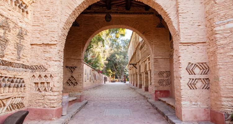 Stenen booggang omlijst een rustige, geplaveide steeg in een traditionele Marokkaanse kasbah bij Taroudannt.