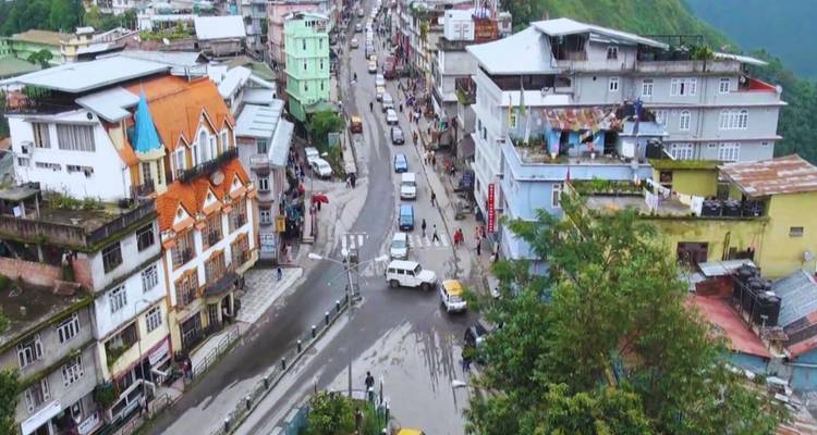 Luftaufnahme einer belebten Hangstadt mit farbenfrohen Gebäuden und gewundenen Straßen.