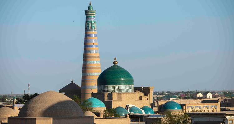 Horizon de Khiva avec dôme vert, minaret rayé et multiples toits en adobe s'étendant jusqu'à l'horizon.